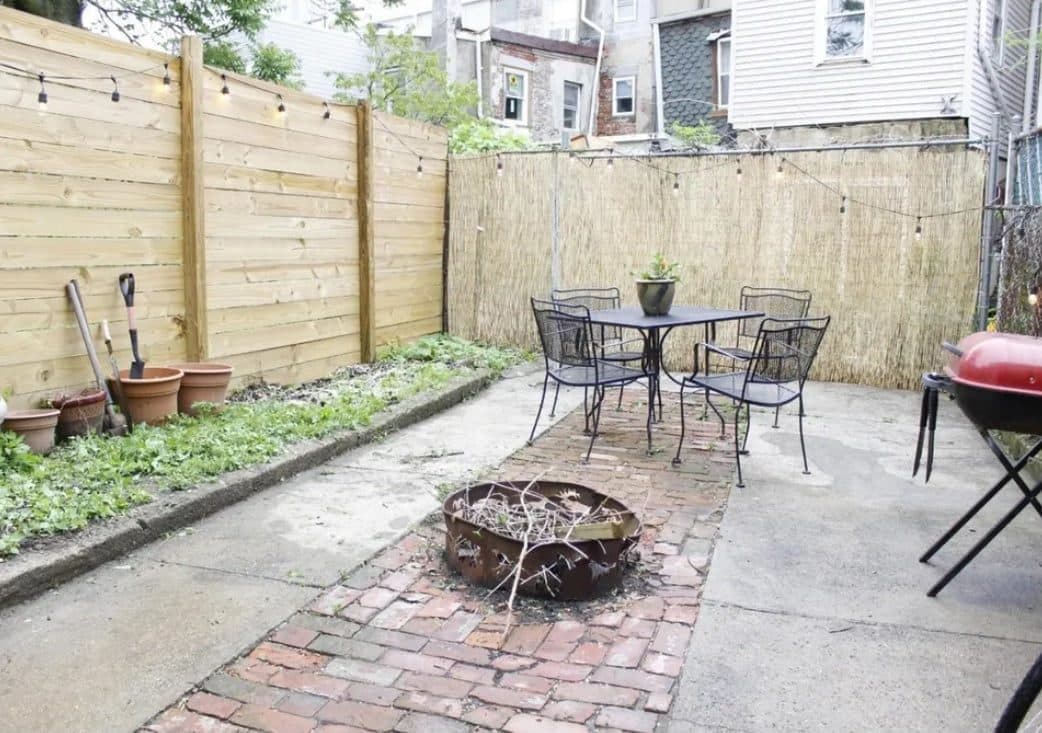 Plain concrete patio before transformation with planning sketch overlay