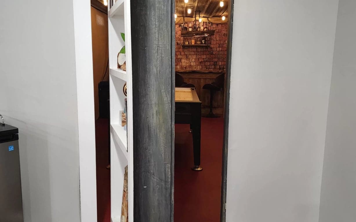 Finished hidden bookcase door built into a basement wall