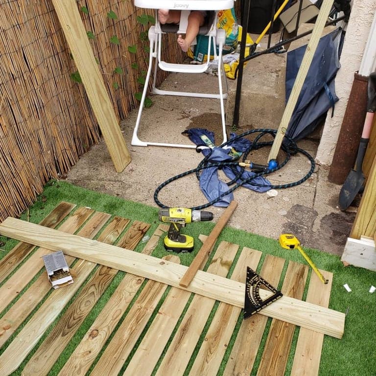 Fourteen fence pickets laid out side by side before the cat-face panel was assembled