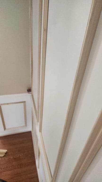 Unpainted picture-frame molding attached to the wall above the white chair rail