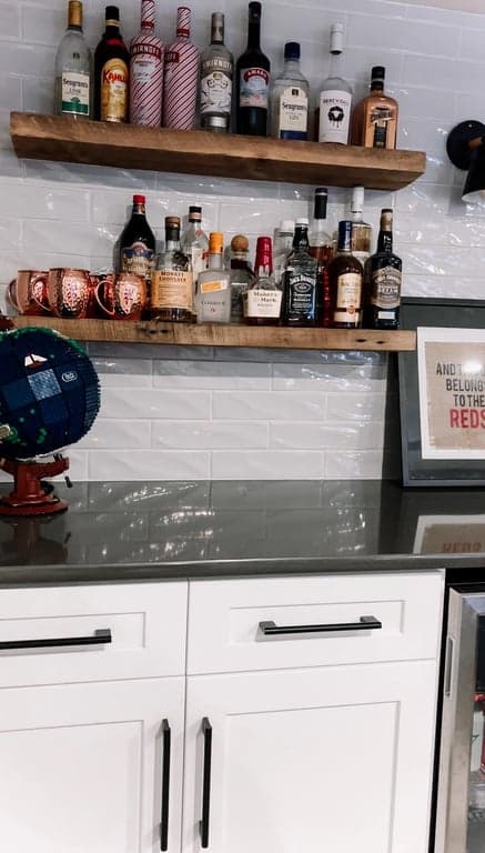 White bar cabinets with dark top and floating shelf