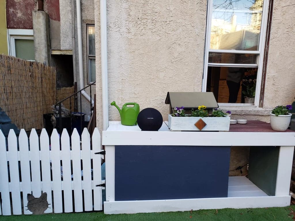 Painted cat-face picket gate installed across the backyard passage