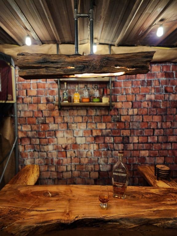 Full bar area with corrugated metal ceiling and barn beam lights