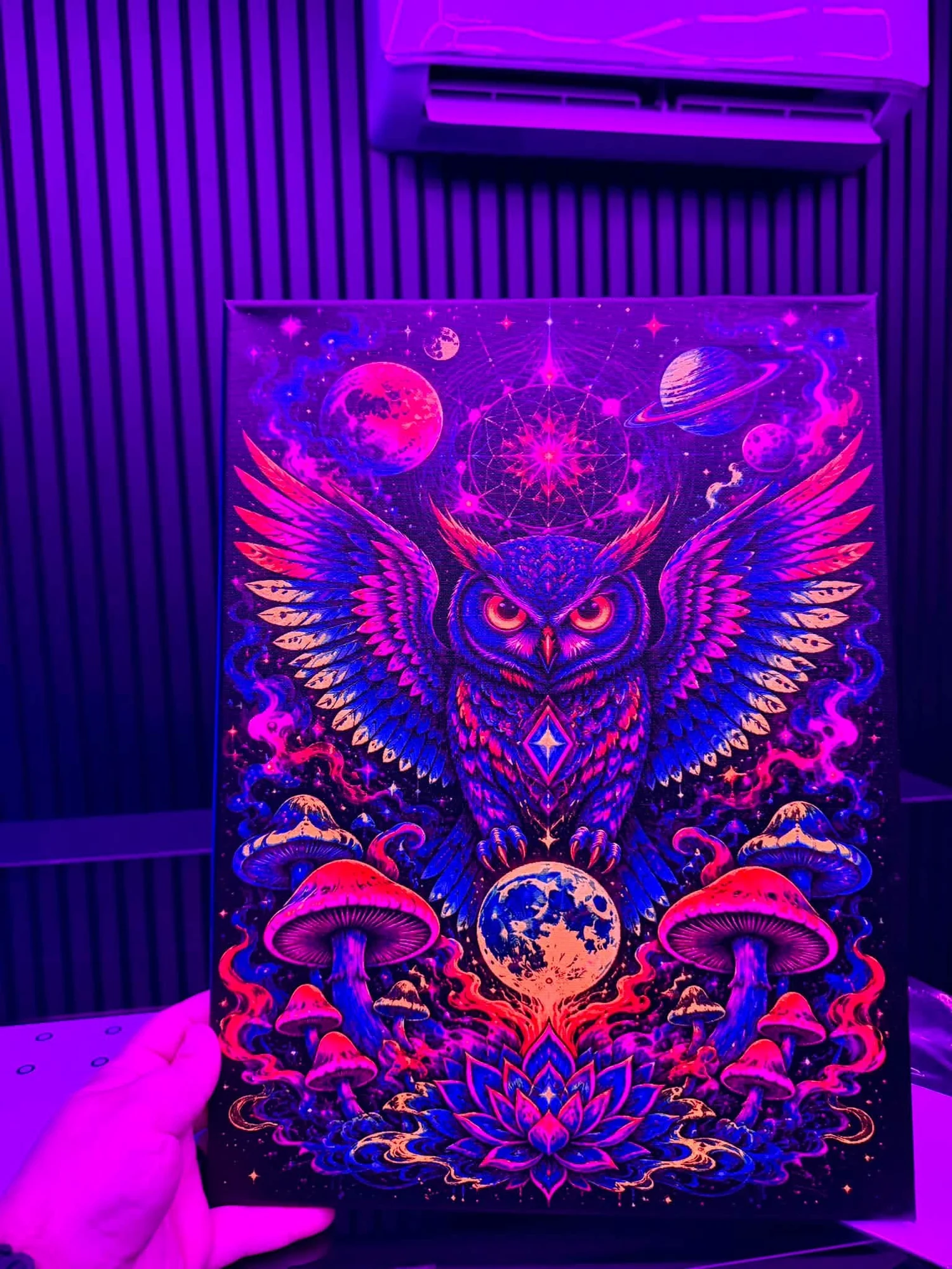 The fluorescent owl canvas glowing in pink and purple UV light.