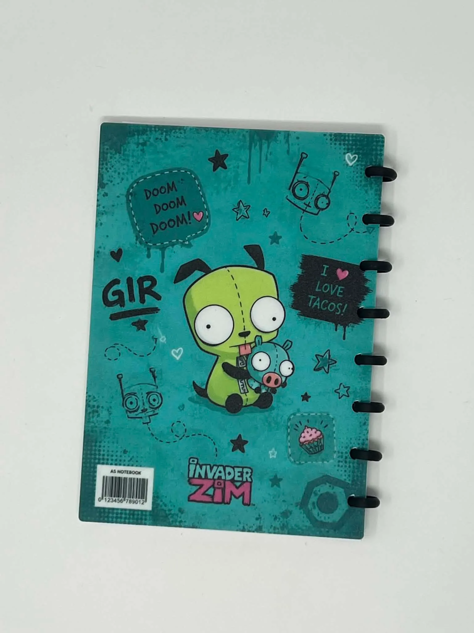The back cover of a teal UV printed A5 disc-bound notebook, showing cartoon artwork and black 3D printed rings.