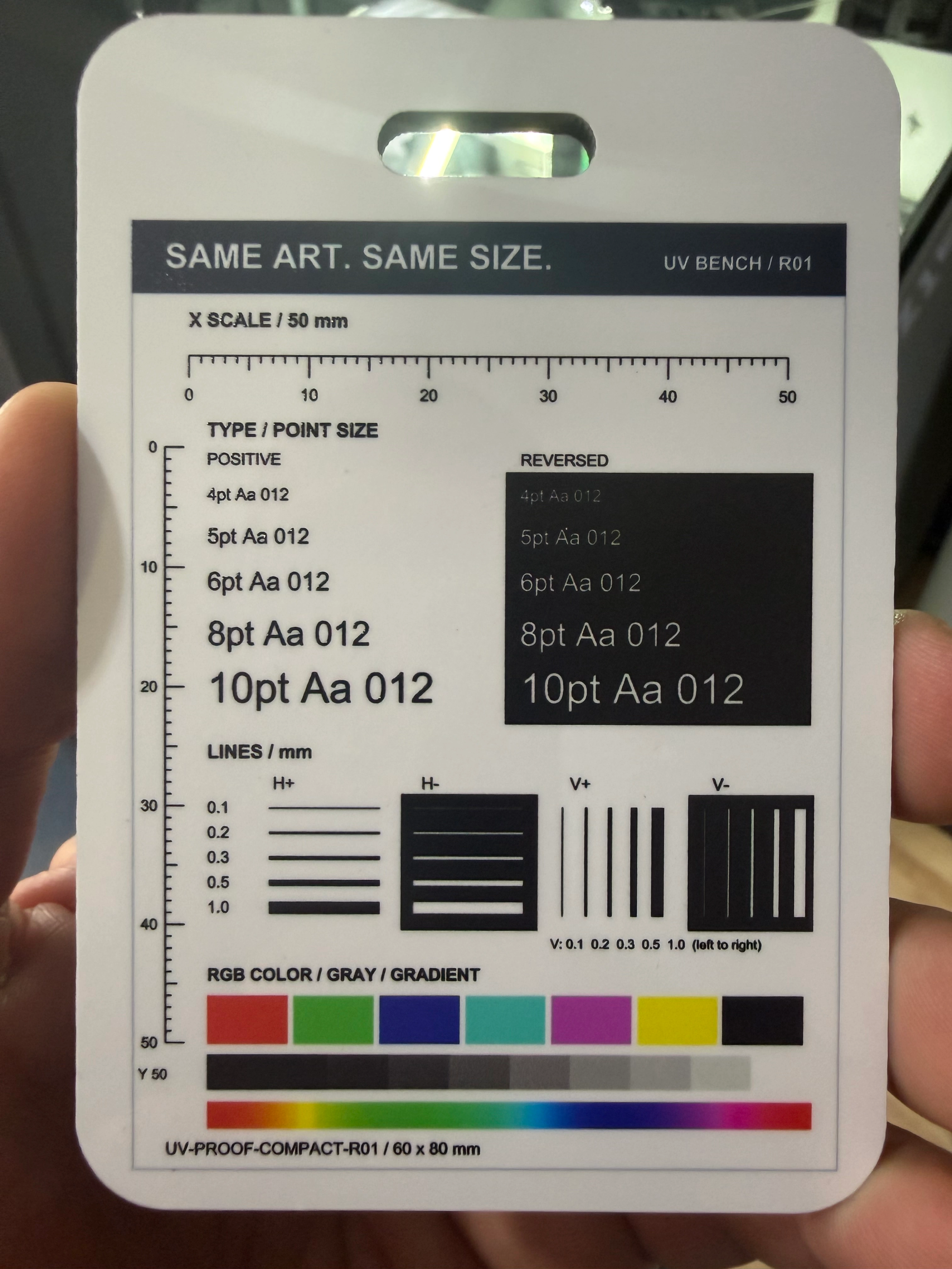 xTool O1 Omni luggage-tag print from our same-day, same-shop E1 comparison, showing fine text, line patterns and color bars.
